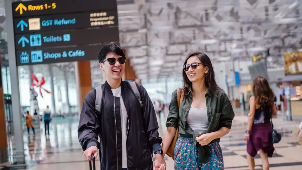 couple in sunglasses at airport.